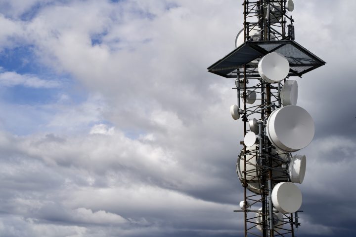 A telecommunications towers against cloudy sky background